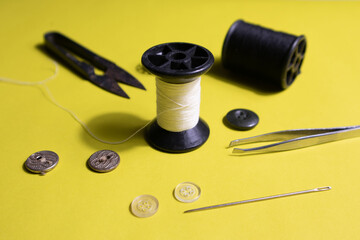 Sewing thread and accessories placed on yellow paper, Close up.
