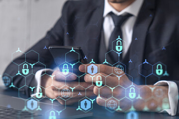 A programmer is browsing the Internet in smart phone to protect a cyber security from hacker attacks and save clients confidential data. Padlock Hologram icons over the typing hands. Formal wear.