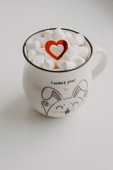White cup with latte and marshmallows with red heart Valentine's Day. Romantic breakfast.