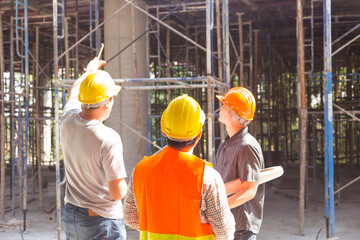 construction engineer who looks after the progress of a construction project stands on the concrete floor.