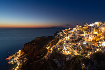 Beautiful view of fabulous caldera view, picturesque village of Oia with traditional white houses under sunset. Amazing travel vacation landscape. Stunning sunset night view Santorini island, Greece