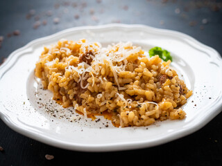 Risotto with chorizo and parmesan on wooden background
