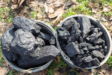 Large chunks of coal in buckets. Procurement of fuel for the winter. Heating of houses in the countryside