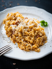 Risotto with chorizo and parmesan on wooden background
