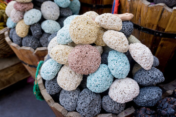 Colored pumice stones for foot care in the wooden baskets on the street market