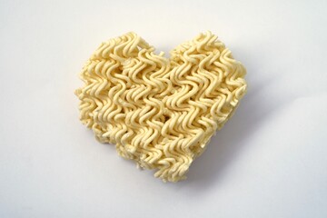Instant noodles in heart shape on white background