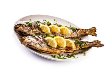 Fish dish - roasted trout with lemon on white background
