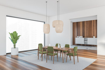 White and wooden room with green chairs and dining table on parquet floor