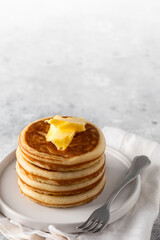 American Breakfast Pancakes with butter on light background for classic breakfast.Copy space
