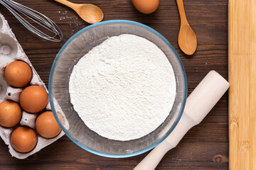 In a glass bowl, flour is poured. Top view. The preparation of bread.