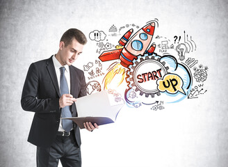 Man reading document and startup sketch