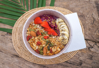 Healthy food Acai breakfast superfoods smoothie bowl with chia seeds, bee pollen, fresh Strawberry, apple, almond and granola for healthy vegan 