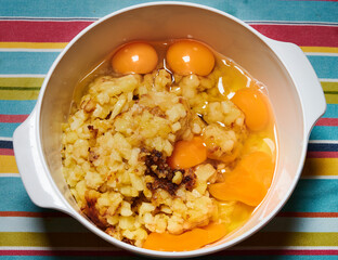 Chopped potatoes frying in extra virgin olive oil and eggs to make spanish omelet.