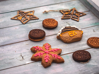 Multicolored gingerbread cookies painted with glaze on a wooden tray