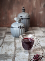 Mug with blackcurrant berry compote and ceramic gray jars