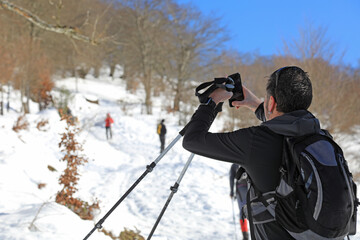 senderista montañero sacando fotografias con el móvil en la nieve país vasco 4M0A8463-as21