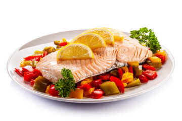 Roast salmon steak with mix of vegetables served on white background
