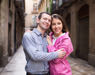 Fototapeta premium young couple guy and girl hugging walking along streets of european city