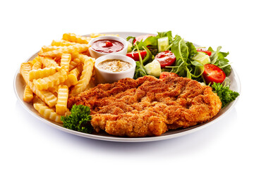 Breaded fried pork chop, French fries and vegetables on white background
