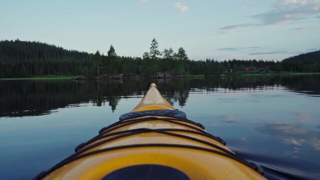 The Bow Of A Yellow Kayak In A Pristine Lake During Sunset In Norway. - POV