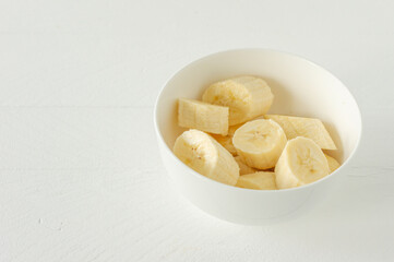 Ripe bananas cut in white bowl for eating. Healthy snack or breakfast concept