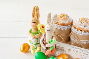 Arrangement decoration Happy Easter holiday background concept. Easter cakes in wooden box with handmade knitted bunny. Pastel colors.