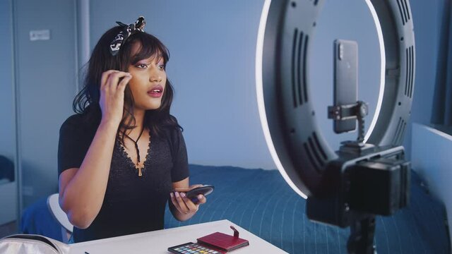 Make up tutorial. Young woman applying make up and presenting new product. Streaming video to sicial media. High quality 4k footage