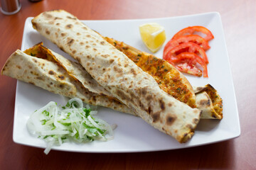 Traditional Turkish pizza (lahmacun) in a white plate