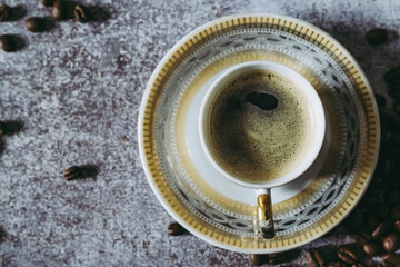 Tasse de café expresso avec des grains de café sur un fond texturé gris