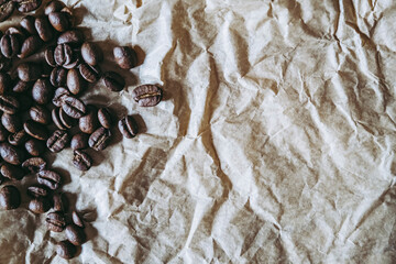 Grains de café placés à gauche sur un fond de papier froissé brun