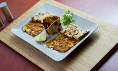 Traditional Turkish pizza (lahmacun) in a white plate