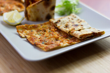 Traditional Turkish pizza (lahmacun) in a white plate