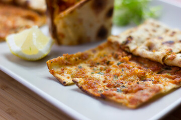 Traditional Turkish pizza (lahmacun) in a white plate