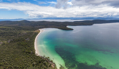 Obraz premium Beautiful high angle aerial drone view of Kingfisher Beach and Jetty Beach in Great Taylors Bay, South Bruny National Park, Bruny Island, Tasmania, Australia. Tasmania mainland in the background.