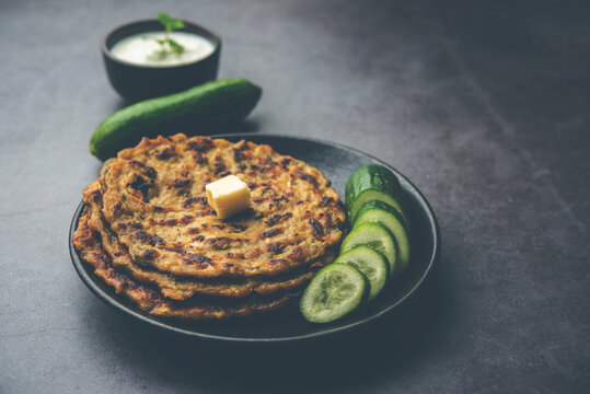 Indian cucumber paratha also known as Kheera&nbsp;parotta&nbsp;or&nbsp;Kakdi Thalipeeth, served with yogurt