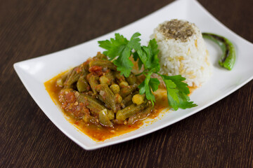 Okra with rice and parsley in a white plate