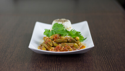 Okra with rice and parsley in a white plate