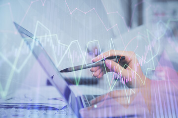 Multi exposure of woman hands typing on computer and financial graph hologram drawing. Stock market analysis concept.