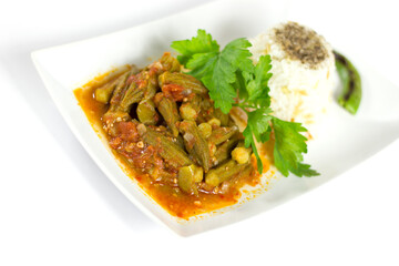 Okra with rice and parsley in a white plate