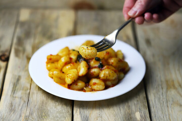 Soft focus. Gnocchi with red sauce on a white plate.