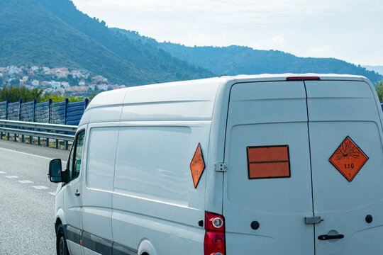 Van transporting explosives, with orange panel and danger labels for expolsion