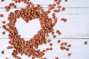 Top view of heart shape space made from heart shape dog food  on white wooden background for Valentine , love and dog lover concept with copy space