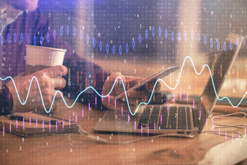 Double exposure of man's hands holding and using a phone and financial graph drawing. Analysis concept.