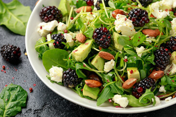 Blackberry salad with greens, almond nuts, feta, avocado and feta cheese
