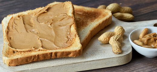 Close-up of peanut butter breakfast toast with fresh peanuts, wide format banner.