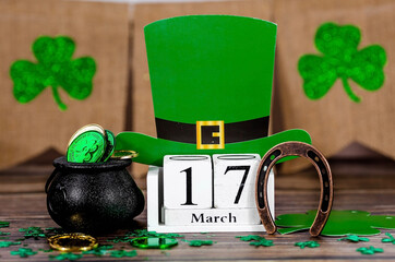 Background for St. Patrick's Day, March 17, with a lucky horseshoe, a leprechaun hat, a clover and...