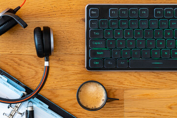 Smart working desktop with laptop, headset, agenda and coffee