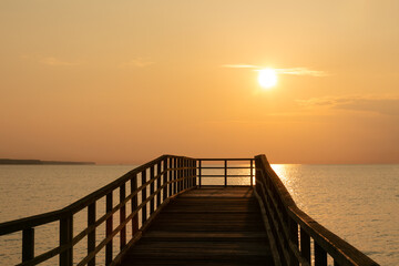 Fototapeta na wymiar Romantic sea pier with golden sunrise, seaside image, seascape texture