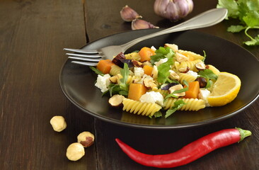 Pasta with baked pumpkin, feta, herbs and hazelnut, copy space