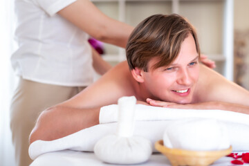 Obraz na płótnie Canvas attractive handsome Caucasian man having body massage by Thai Masseur in spa salon. Beauty treatment and body care lifestyle concept